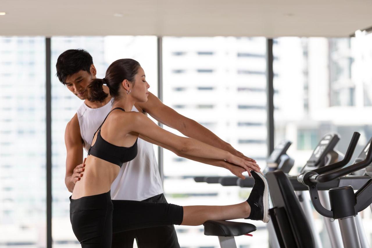 Ascott Thonglor Bangkok Hotel Eksteriør billede A personal trainer assisting a woman with a stretching exercise